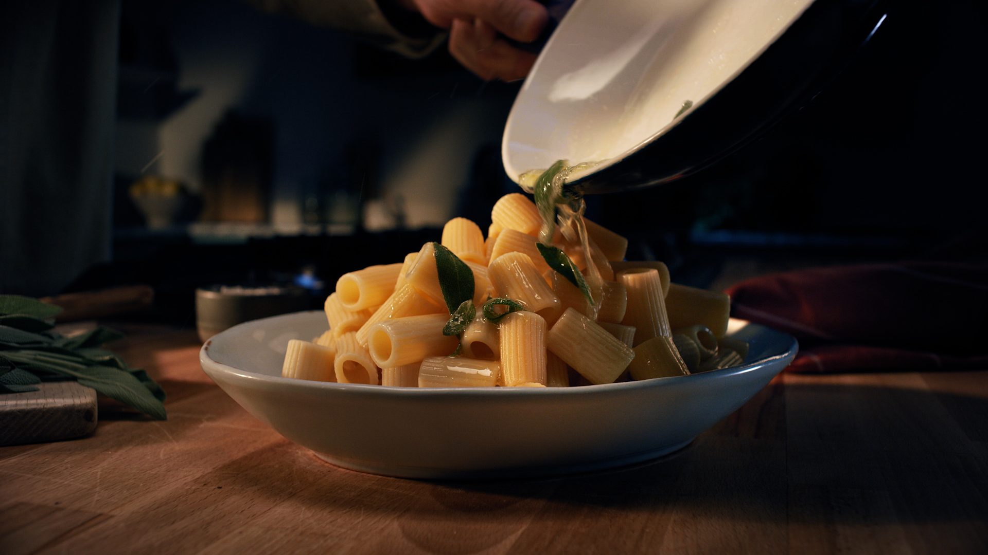 Pasta met salieboter wordt uit de pan in een kom geschept