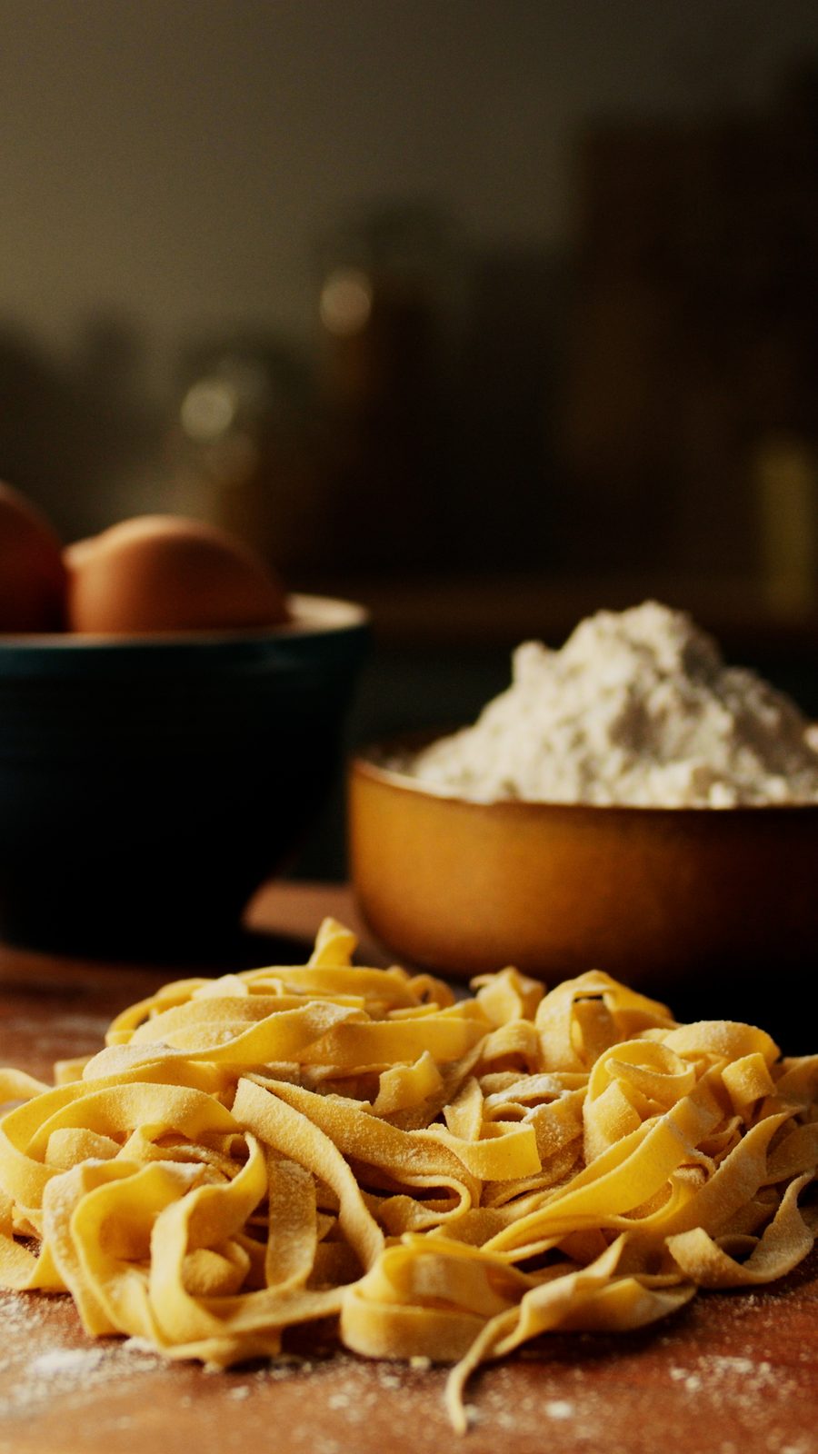 Vers pastadeeg in linten op een houten plank